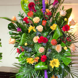 Tall standing floral spray with roses and bright mixed blooms
