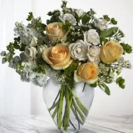 Bouquet of cream and white roses in a clear glass vase