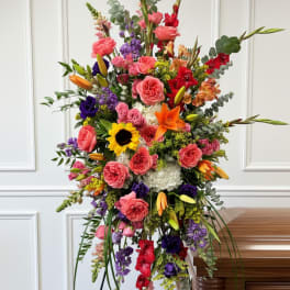 Tall standing floral spray with roses, lilies, and sunflowers
