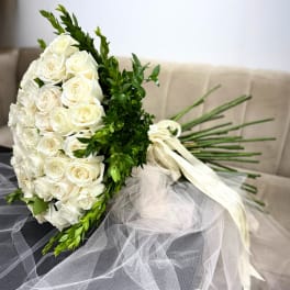 White rose bouquet with greenery and a white ribbon