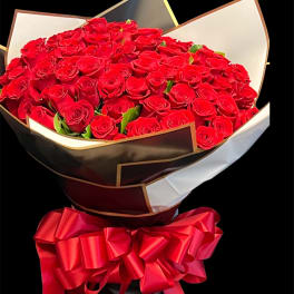 Large bouquet of red roses wrapped in black and white paper with a red ribbon