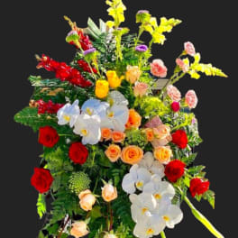 Tall standing floral spray with red, white, yellow, and peach blooms