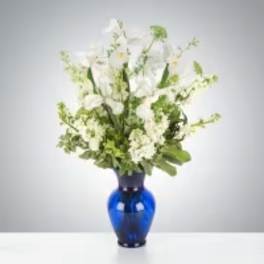 White floral arrangement in a blue glass vase