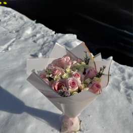 Bouquet of pink and white roses wrapped in white paper