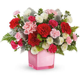 Pink and red carnations in a pink glass vase