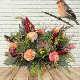 Mixed bouquet with peach and pink flowers and a bird figurine on a branch
