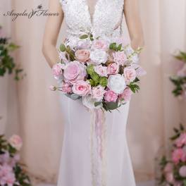 Bride holding a pink and white rose bouquet with trailing ribbons