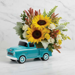 Sunflowers arranged in a turquoise toy truck
