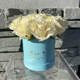 White roses arranged in a light blue round box