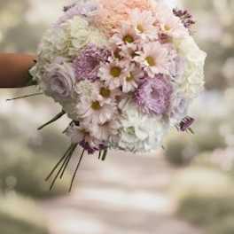 Pastel bouquet of daisies and roses held in hand