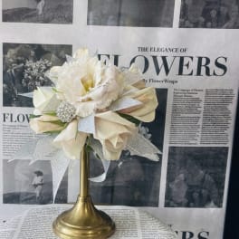 Cream-colored bouquet on a gold pedestal stand with silver ribbon accents