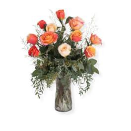 Orange and peach roses in a clear glass vase