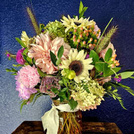 Mixed bouquet in a glass jar vase with pale pink and cream blooms