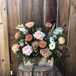 Peach and blush roses with dahlias and ranunculus in a rustic wooden box centerpiece