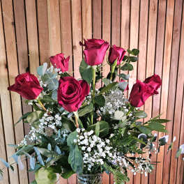 Bouquet of red roses with baby's breath in a clear glass vase