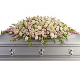 Pastel floral casket spray on a silver casket