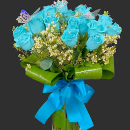 Blue roses in a glass vase with a bright ribbon bow