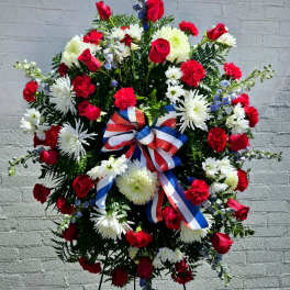 Large red, white, and blue floral standing spray with ribbon bow