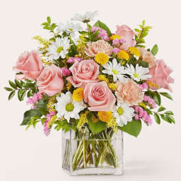 Pink roses and white daisies in a clear glass vase