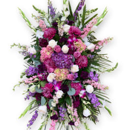 Large standing spray of pink, purple, and white flowers on an easel