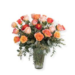 Bouquet of orange and pink roses in a clear glass vase