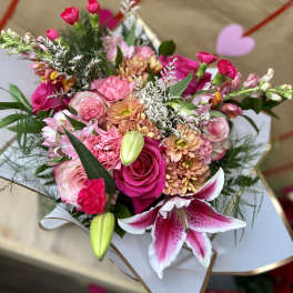 Pink mixed bouquet with roses, lilies, and chrysanthemums in white wrap