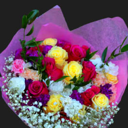 Bouquet of pink, yellow, and white roses wrapped in purple paper