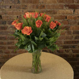 Orange roses arranged in a clear glass vase