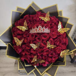 Heart-shaped bouquet of red roses with gold butterfly decorations and a tiara