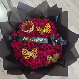 Bouquet of red roses wrapped in black paper with gold butterfly decorations