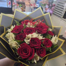 Bouquet of red roses and white flowers with a "Love You" topper