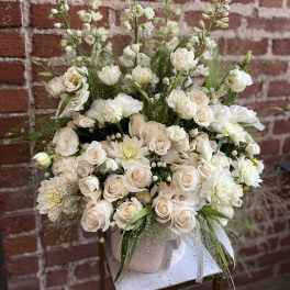 White roses and mixed white blooms arranged in a vase
