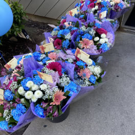 Bouquets of colorful mixed flowers wrapped in purple paper