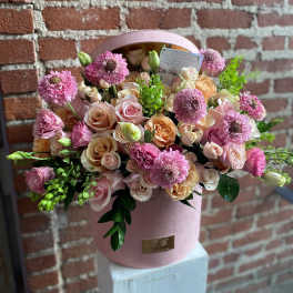 Pink and peach rose bouquet in a round pink box with green accents