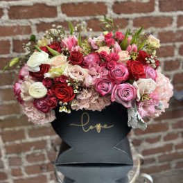 Mixed bouquet of roses, tulips, and hydrangeas in a black box
