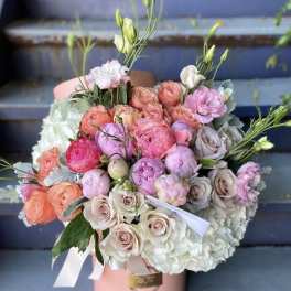 Pink and peach rose bouquet with white hydrangeas in a pink hatbox