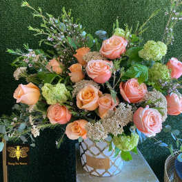 Peach roses and green hydrangeas in a decorative vase