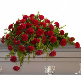 Red carnation casket spray with trailing greenery
