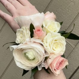 Small bouquet of pale pink and white roses and ranunculus in hand
