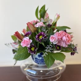Pink and purple mixed bouquet in a blue-and-white vase
