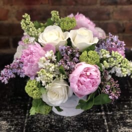 Pink and white flower bouquet in a white container