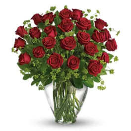 Red roses arranged in a clear glass vase