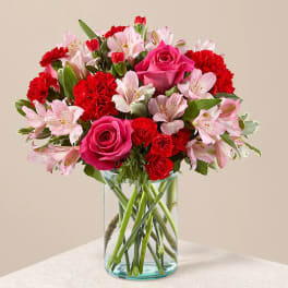 Pink roses and red carnations in a clear glass vase