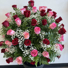 Large arrangement of red and pink roses in a black vase