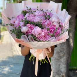 Large bouquet of pink peonies wrapped in pale pink paper