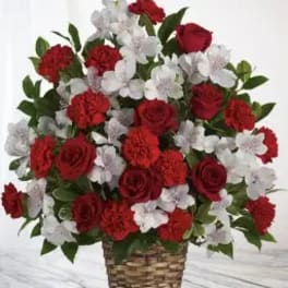Red roses and white flowers arranged in a woven basket