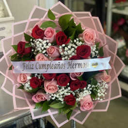 Bouquet of red and pink roses with baby's breath and a birthday ribbon