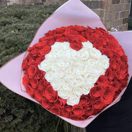 Large bouquet of red and white roses wrapped in pink paper