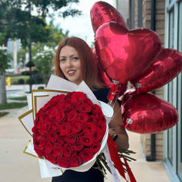 Woman holding a bouquet of red roses and red heart balloons