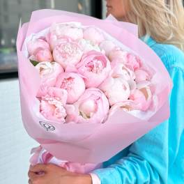 Bouquet of pale pink peonies wrapped in pink paper